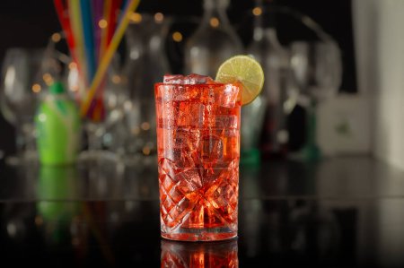 Cocktail. Red cocktail on a tall glass with a slice of lime.