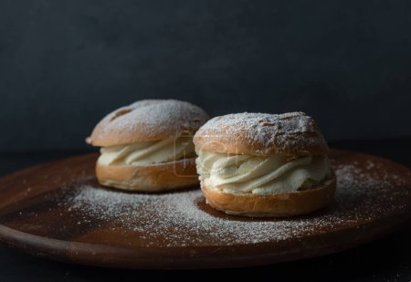 Traditional Swedish pastry. Semla or semlor, flavored with cardamom, filled with almond paste and whipped cream from Sweden, Finland, Estonia, Norway and Denmark for Shrove Monday fat Tuesday, Easter