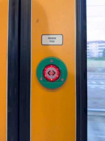 Foto de Un detalle de un botón de salida y puertas coloridas e iluminadas, de un tren rápido Malpensa Express, en el camino a Milán, Milán, Italia - Imagen libre de derechos