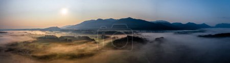 Sunset Panorama with drone at the Bavarian Alps. Mist and fog at the ground. High quality photo