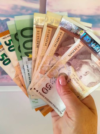 Frauenhände aus nächster Nähe. Eine Frau hält Euro- und Lev-Banknoten in den Händen. Geschäfts-, Finanz- und Vergütungskonzept.