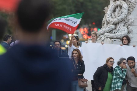 Téléchargez les photos : 29-10-2022 LISBONNE, PORTUGAL : RALLEMENT DÉDIÉ À MAHSA AMINI - jeune femme souriante agitant le drapeau. À mi-coup - en image libre de droit