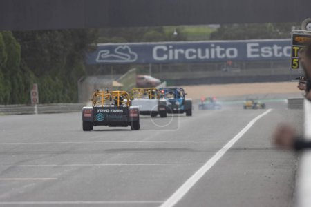 Photo for 11-20-2022 PORTUGAL, LISBON: Caterham festival - racing karts with advertising stickers on the back driving in a row on the track. Mid shot - Royalty Free Image