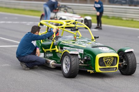 Photo for 11-20-2022 PORTUGAL, LISBON: Caterham festival - staff worker talks to a racer sitting in the kart. Mid shot - Royalty Free Image