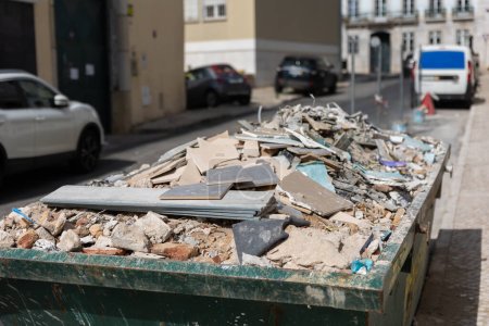 Foto de Residuos de construcción en un contenedor en la calle. Mid shot - Imagen libre de derechos
