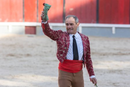Photo for March 26, 2023 Lisbon, Portugal: Tourada - scratched elderly male tereador on the arena with his hand up holding a handkerchief. Mid shot - Royalty Free Image
