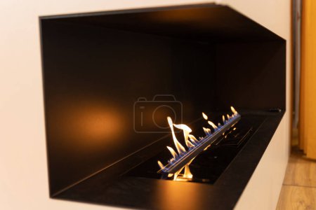 Photo for Innovative home fireplace - flames behind the glass. Mid shot - Royalty Free Image