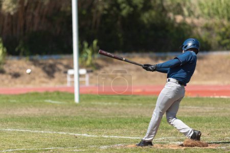 Foto de El juego de béisbol - el bateador en uniforme azul a punto de golpear la pelota. Mid shot - Imagen libre de derechos