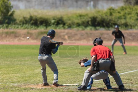 Foto de La competencia de béisbol - el bateador a punto de golpear la pelota. Mid shot - Imagen libre de derechos