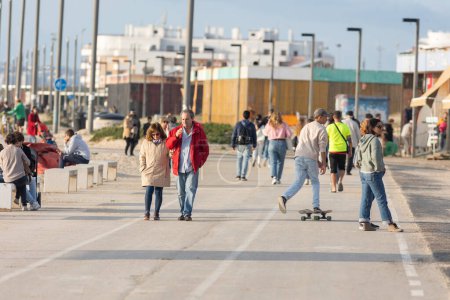 Photo for 25 november 2023, Lisbon, Portugal - People walking on promenade near ocean - telephoto - Royalty Free Image