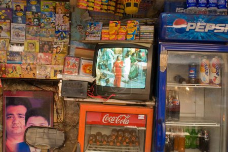 Téléchargez les photos : Télévision jouant des vidéos de musique dévotionnelle placées sur le réfrigérateur de coca cola, Rishikesh, Uttaranchal Uttarakhand, Inde - en image libre de droit