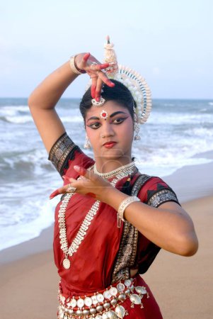 Photo for Dancer performing classical traditional odissi dance in front of bay of Bengal sea, Konarak, Orissa, India - Royalty Free Image