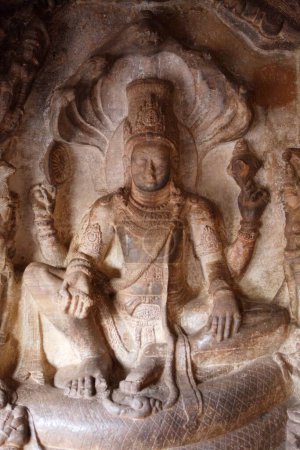 Foto de Escultura de Vishnu sentado en sesha en la postura Lalitasana de la facilidad real en la shesha de serpiente cósmica en Badami, Cueva de Chalukya, Patrimonio de la Humanidad por la UNESCO, Bagalkot, Karnataka, India - Imagen libre de derechos