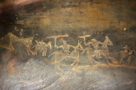 Foto de Pinturas rupestres que muestran a hombres a caballo con brazos en refugios rocosos no 7 diez mil años de edad en Bhimbetka cerca de Bhopal, Madhya Pradesh, India - Imagen libre de derechos