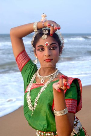 Photo for Dancer performing classical traditional odissi dance in front of bay of Bengal sea, Konarak, Orissa, India - Royalty Free Image