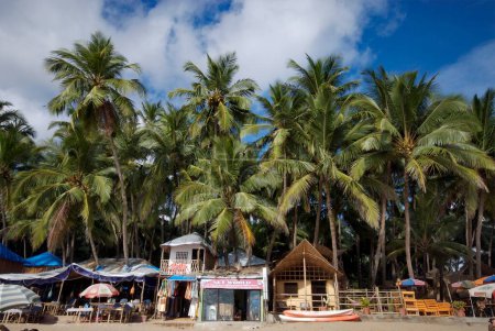 Téléchargez les photos : Cabanes sous les cocotiers et bateaux à la plage de Palolem, Goa, Inde - en image libre de droit