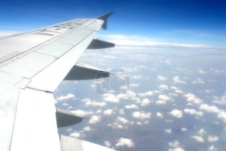 Photo for View of cloud in blue sky and wing of plane from aeroplane window - Royalty Free Image