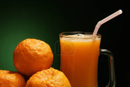 Téléchargez les photos : Fruits, Oranges avec un verre de jus d'orange sur fond vert noir - en image libre de droit