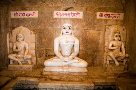 Three Idols of Teerathnkar Shri Rishabh devji and Shri Dada Guruji in Meditation padmasan yogic posture dhyan , Adinath Jain temple , Village Delwara , Udaipur , Rajasthan , India