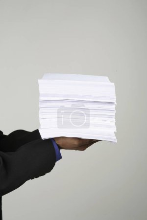 Téléchargez les photos : Exécutif tenant pile de papiers, fond blanc - en image libre de droit