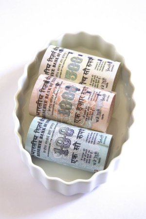 Téléchargez les photos : Concept, monnaie indienne cent cinq cent mille roupies dans un bol - en image libre de droit