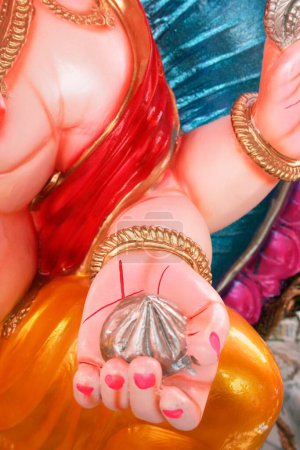 Photo for Left palm of colourful idol of lord ganesha elephant headed god having sweet called modak , Pune , Maharashtra , India - Royalty Free Image