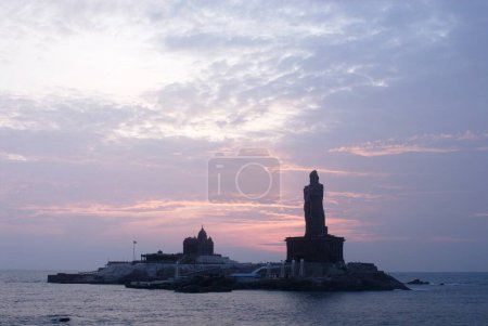 Sunrise behind Swami Vivekananda Rock Memorial and Thiruvalluvar statue immortal poet , Kanyakumari , Tamil Nadu , India