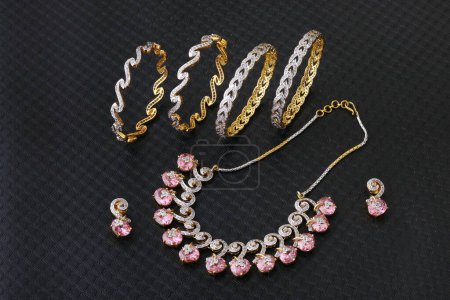 Foto de Pulseras y orejeras collar de joyería de oro diamante sobre fondo negro - Imagen libre de derechos