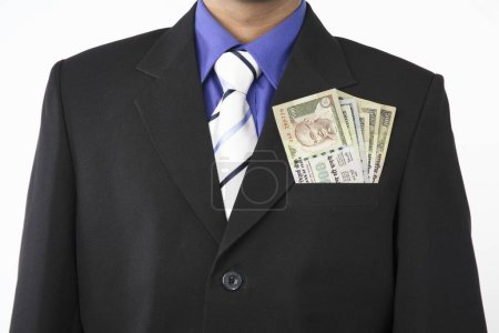Photo for Executive with pile of money in pocket, white background - Royalty Free Image