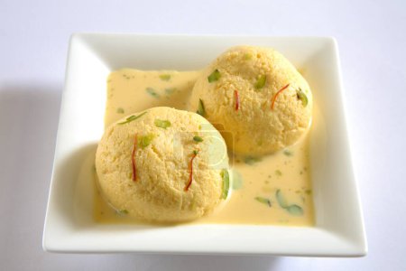 Photo for Indian sweet , kesar rasmalai garnish with pistachio and saffron served in plate - Royalty Free Image