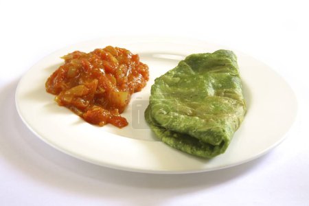 Indian cuisine , fast food crispy Palak Spinach Puri with tomatoes masala bhaji or sabzi served in dish on white background