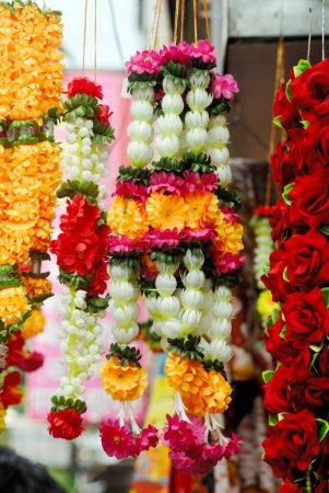 Téléchargez les photos : Des guirlandes colorées de fleurs artificielles suspendues à vendre utilisées pour la décoration du festival Ganpati, Dadar, Bombay Mumbai, Maharashtra, Inde - en image libre de droit