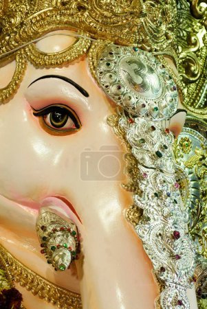 Photo for Eye and tusk of richly decorated forehead idol of lord ganesh elephant headed god for Ganpati festival , Shree Tulsibaug Ganpati fourth in honour at Pune , Maharashtra , India - Royalty Free Image