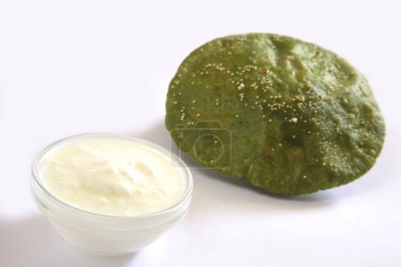 Indian cuisine , fast food crispy Palak Spinach Puri with curd served in dish on white background