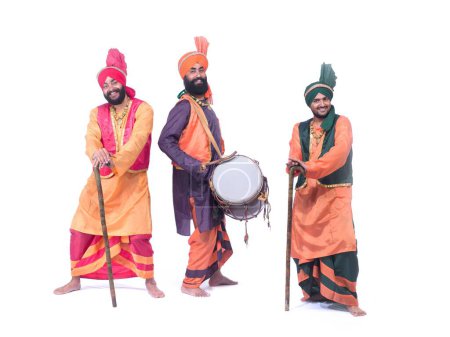 Foto de Bailarines tocando instrumentos musicales dholak realizando danza folclórica bhangra - Imagen libre de derechos