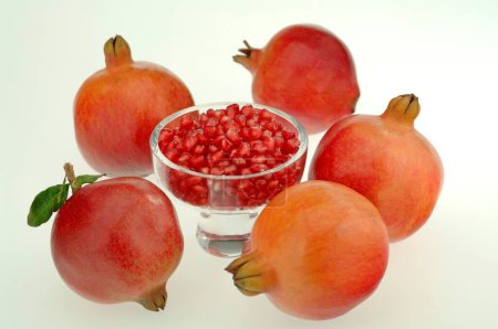 Frutas, Cinco piezas Granada con semillas en copa de vidrio sobre fondo blanco