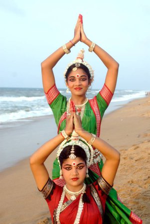 Téléchargez les photos : Danseurs exécutant la danse traditionnelle classique odissi devant la baie de la mer du Bengale, Konarak, Orissa, Inde - en image libre de droit