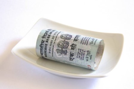 Concept Indian currency one hundred rupees in plate