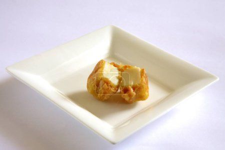 Foto de Cocina india, entrantes de comida rápida Cheese Pakode puffs servidos en plato sobre fondo blanco - Imagen libre de derechos