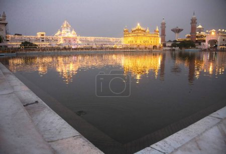 Harimandir Sahib illuminé swarn mandir or temple reflet dans l'étang, Amritsar, Punjab, Inde