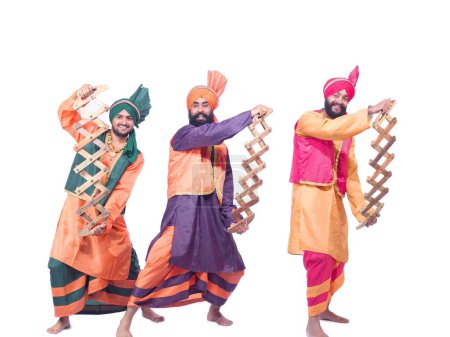 Foto de Bailarines tocando instrumento musical realizando danza folclórica bhangra - Imagen libre de derechos