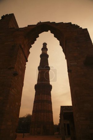 Foto de Vista nocturna de Qutab Minar a través del arco construido en 1311 torre de arenisca roja, arte Indo _ Muslim, sultanato de Delhi, Delhi, India Patrimonio de la Humanidad por la UNESCO - Imagen libre de derechos