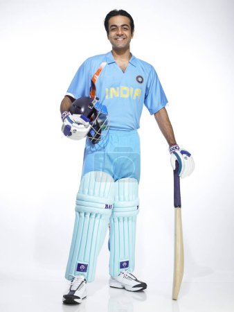 Indischer Schlagmann hält Schläger und Helm für Cricket-Match bereit 