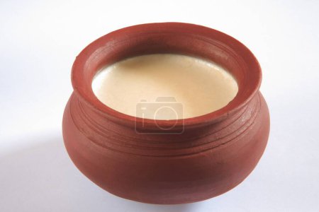 Indian sweet , mishti doi curd served in earthen pot on white background