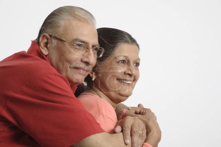 Old couple , old man holding old woman close to him and smiling 