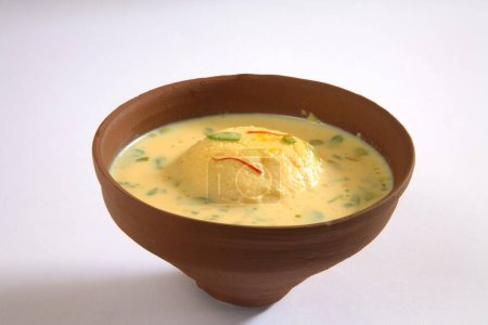 Photo for Indian sweet , kesar rasmalai garnish with pistachio and saffron served in earthen pot - Royalty Free Image