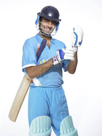 Indischer Schlagmann mit Handschuhen bereitet sich auf Cricket-Match vor