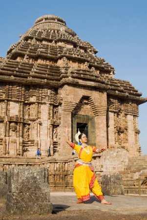 Téléchargez les photos : La pose de la danseuse Odissi reproduit des mythes indiens tels que le Ramayana devant le complexe du temple solaire du patrimoine mondial à Konarak, Orissa, Inde - en image libre de droit
