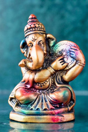 Foto de Señor Ganesha ganpati yeso ídolo sentado colorido tocando tambor de mano dafli indio timbales musicales Instrumento - Imagen libre de derechos