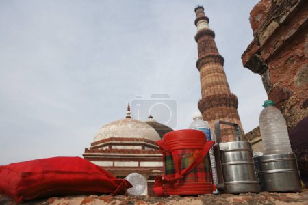 Téléchargez les photos : Déjeuner Boîtes Tiffin et bouteilles d'eau à Qutab Minar construit en 1311 tour de grès rouge, Delhi, Inde Patrimoine mondial de l'UNESCO - en image libre de droit